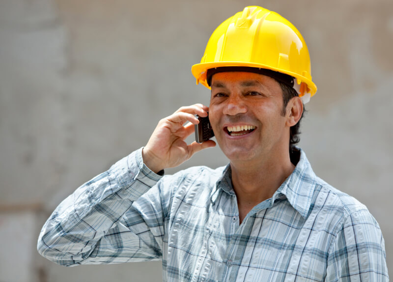 Construction worker in a hardhat talking on the phone.