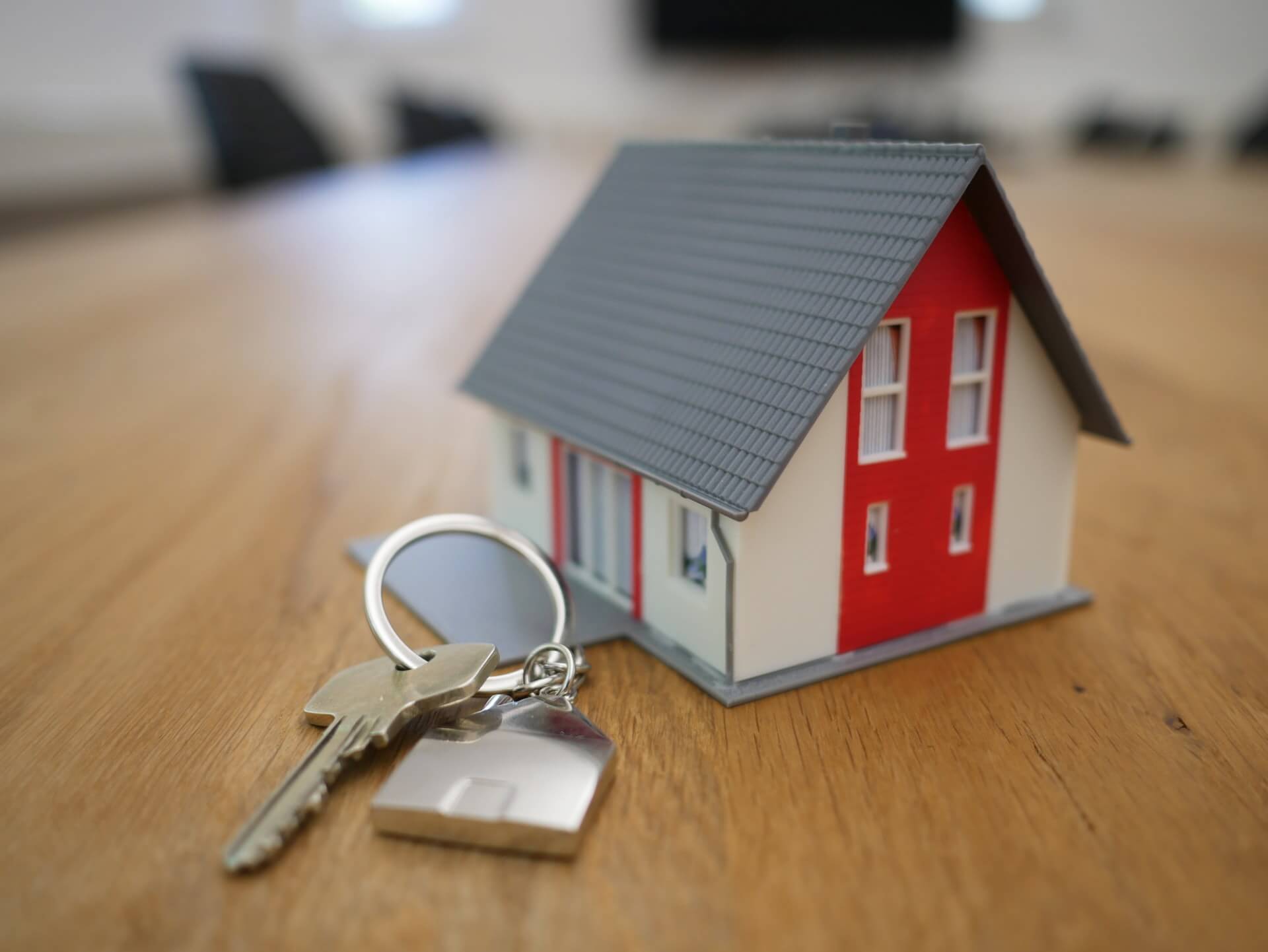 small model house with keys on a ring beside