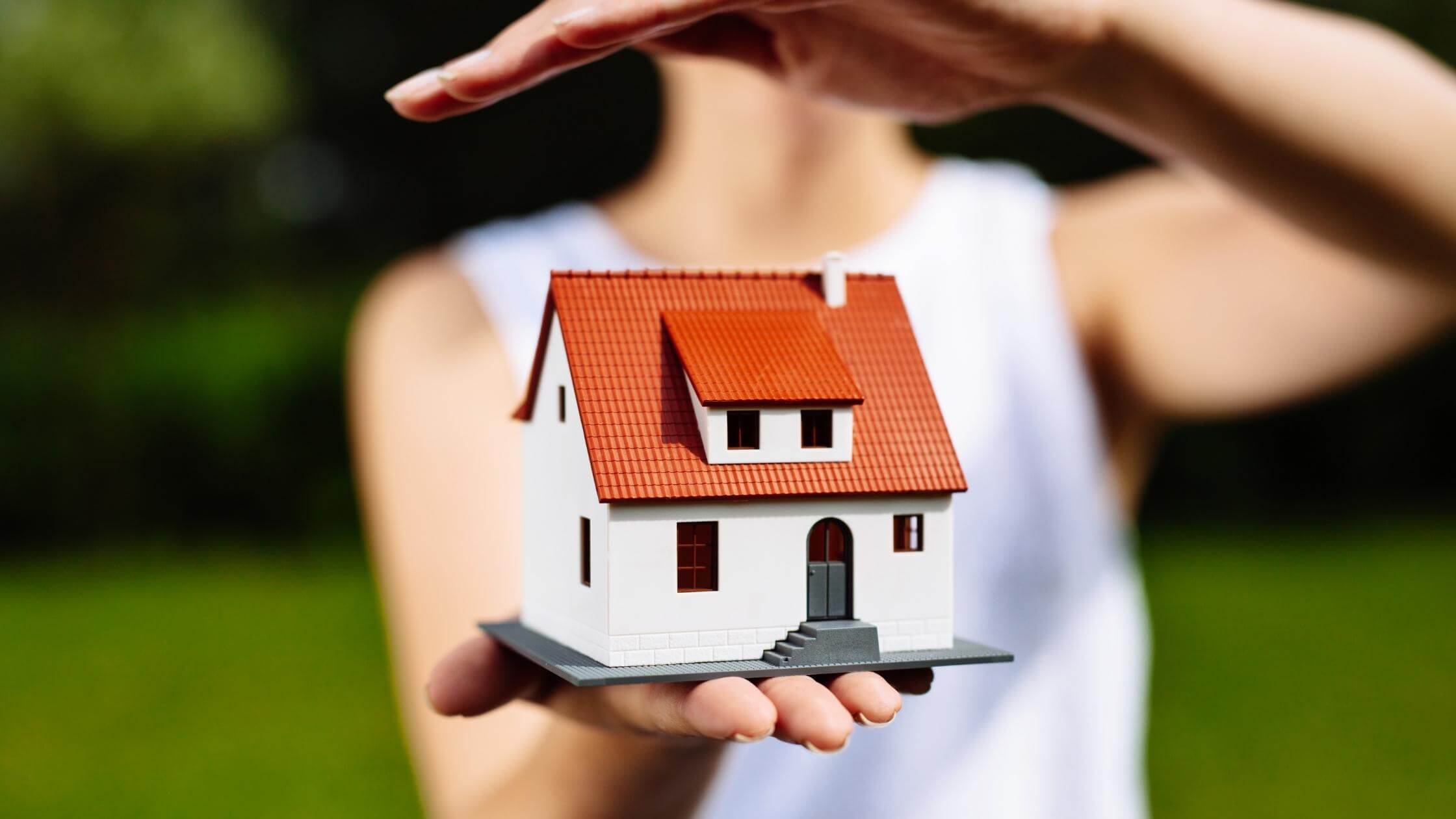 woman holding model house in hand