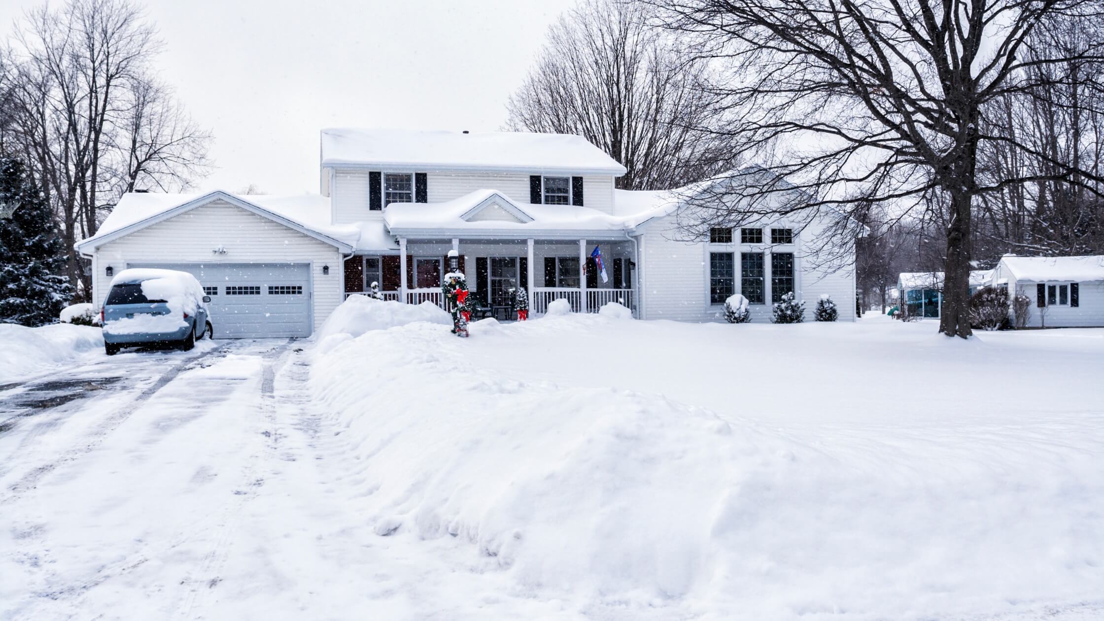 house with lots of snow in driveway