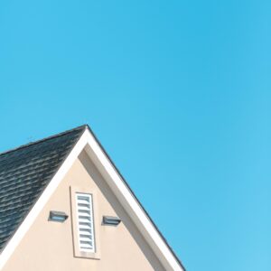 A house with a roof and a window, featuring a vent exhaust for enhanced air circulation.